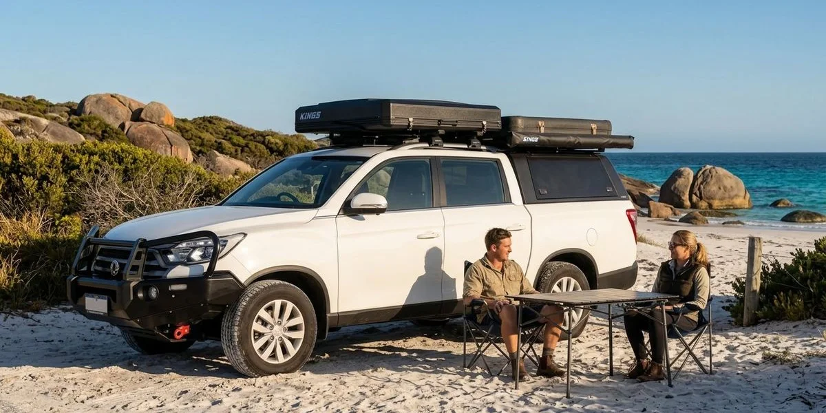 4WD camper with rooftop tent parked near turquoise ocean at a coastal campsite in Western Australia with clear blue sky