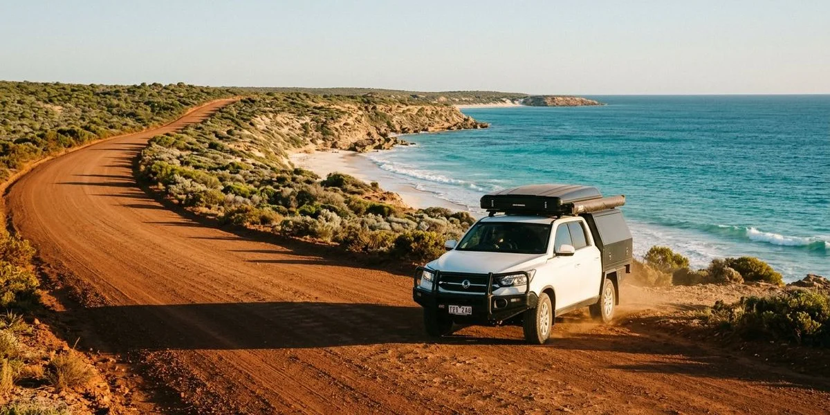 OFFGRID Wanderer driving along a scenic coastal road in Western Australia with turquoise water in the background
